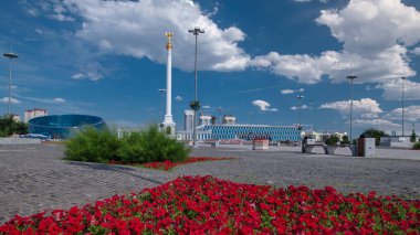 Yıldız heykeli Kazak Eli 'ın kuş Samruk ve Bağımsızlık Sarayı' nın zaman atlaması ve kırmızı çiçek tarhı ön planda. Nur-Sultan şehri, Kazakistan
