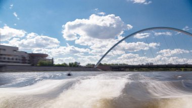 Astana, Kazakistan. Keyif teknesinden Astana 'da Ishim nehrinde hareketli bir seyahat görüntüsü. Mavi gökyüzü ve bulutlarla dolu bir yaz gününde. Bulanık hareket