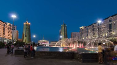 Su Yeşili Bulvarı 'nda, gece vakti, şelaleli hiperhız. Başkan sarayı arka planda. Astana 'nın yeni iş ve idari merkezindeki yaya bölgesi. Işıklar yanıyor..