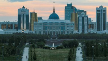 Astana şehrinin gece gündüz geçiş zamanlarını ve başkanın Akorda 'daki park yerini kapatın. Barış ve Uzlaşma Sarayı 'ndan görüntü. Nur-Sultan şehri, Kazakistan