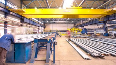 Vinç cihazını kaldıran fabrika atölyesi hiperhızlandırma, kaldırma operatörü yükleri kaldırma mıknatısı, mekanik atölye, metal yapılar fabrikası. Kesin metal kesimi için otomatik makine.