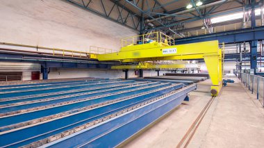 Factory workshop with yellow lifting crane device timelapse hyperlapse, lift loads using lifting magnet, mechanical workshop, metal structures plant. Automated machine for precise metal cutting.