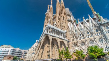 Sagrada Familia: İspanya 'nın Barcelona kentindeki Iconic Roma Katolik Kilisesi' nden Timelapse Hyperlapse. Sonbaharın Zarif Yeşilliği ve Mavi Bulutlu Gökyüzünün Altında Açılan Mimari Mucizeye Şahit Ol.