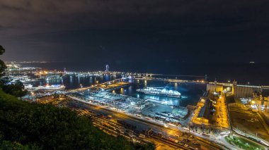 Port Vell timelapse, Barcelona, Katalonya, İspanya ile Montjuic gece manzarası. Gemi ve terminal ile Hill Hava üstten görünüm