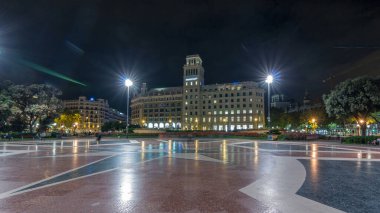 Orta Barselona 'daki Aydınlanmış Placa de Catalunya' nın Zaman Hızı. Şehir Merkezi Olarak Büyük Bir Meydan, Merkez Çeşme ve Gece Tepesi Arkaplanı Olarak Çiçek Yatağı