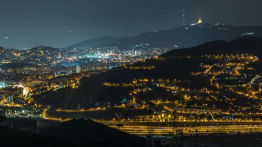 Barcelona ve Badalona Skylines 'ın Gece Zamanlaması. İberik Puig Castellar Köyü 'nden Havadan Bakış Alanı, Evlerin Çatıları, Ufukta Tibidabo, Yıldızlı Gece Gökyüzü Altında Aydınlandı