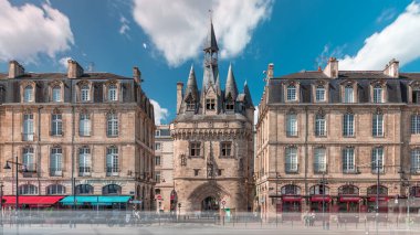 Ortaçağ mimarisi ve kuleleriyle Fransa 'nın Bordeaux kentinde tarihi Porte Cailhau zaman atlaması. Şehir manzaraları caddelerde tramvay trafiği ile birlikte geçidi ve canlı çevreyi gösteriyor.