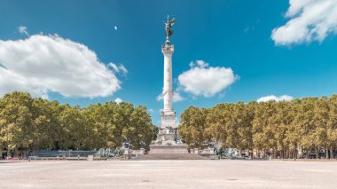 Bordeaux, Fransa 'da Esplanade Des Quinconces zaman ayarlı fıskiyeli Aux Girondins Anıtı. Tarihi eser ve mimari şaheser özgürlüğü ve devrimi simgeliyor. Mavi bulutlu gökyüzü