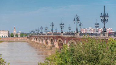Bordeaux 'daki tarihi Stone Köprüsü Pont de Pierre zamanapse, Garonne Nehri' ni kemerler ve klasik sokak lambalarıyla kaplar. Şehri birbirine bağlayan bir dönüm noktası, geçen tramvaylar ve yürüyen yayalar.