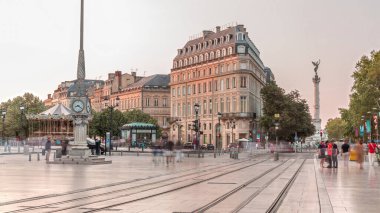 Günbatımında Place de la Comedie Timelapse, Bordeaux, Fransa 'da üçgen bina ve modern tramvay. Gölgeler ön cephede ilerler ve saatli bir sokak lambası bu şehir simgesine zarafet katar.