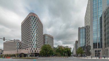 Baudouin Bulvarı, Brüksel, Belçika 'daki iş bölgesi zaman çizelgesinde trafik ve modern ofis binalarını gösteren panorama. Kavşağın yanındaki çağdaş kuleler bulutlu bir gökyüzünün altına park ederler.
