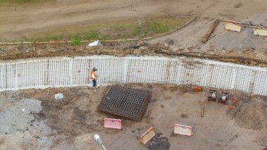 Şehir karayolu inşaatı zamanındaki tramvay rayları için koruyucu maske takviyesi olan işçilerin hava görüntüsü. Tramvay raylarının yeniden inşası.