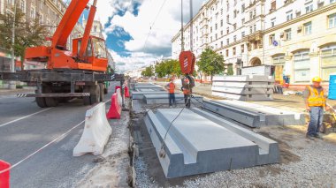 Vinç yol inşaat site timelapse hyperlapse, beton plaka yükleme. Kavganın ve üniforma ile sanayi işçileri. Sokak şehir tramvay yeniden inşası izler