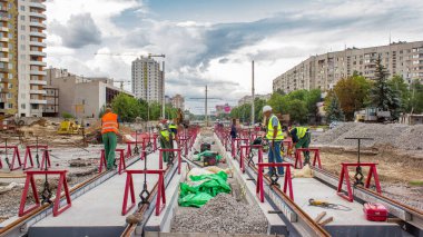 Kurulum aşamasındaki tramvay rayları ve zaman dilimindeki beton plakalara entegrasyon. Tramvay raylarının yeniden inşası. Bulutlu gökyüzü