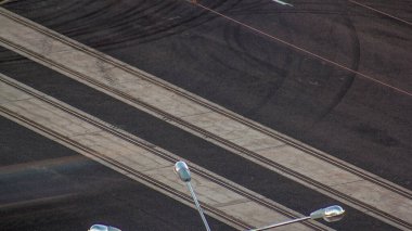 Şehir caddesinde yeni yeniden inşa edilmiş tramvay rayları olan bir kavşak. Yeni asfalt yolu yapım aşamasında olan hava manzaralı..