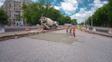 Tramvay rayları onarımı ve bakım zamanı olan bir yol inşaatı. Beton, kavşağın ortasında mikserle çalışıyor. Yeni toplu taşıma için demiryolu raylarının değiştirilmesi