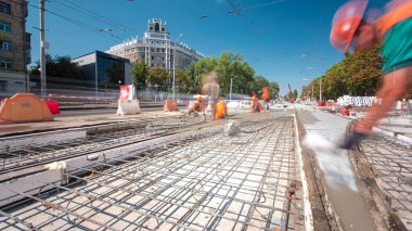 Beton yol yapım birçok işçi ve mikser timelapse hyperlapse ile çalışıyor. Harç metal takviye için dökme. Kaplama ve koruyucu filtre püskürtücü tarafından. Tramvay parça yeniden inşası