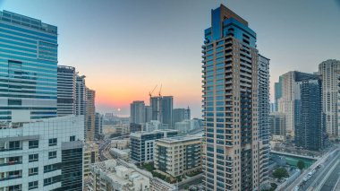 Dubai Yat Limanı hava görünümünü günbatımı timelapse adlı bir noktadan. Modern gökdelenler ve konut kuleleri sıcak akşam ışıkla aydınlatılmış
