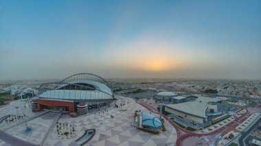 Doha 'da güneş doğarken Aspire Bölgesi' nin havadan görüntüsü. Yollarda ve araba parklarında trafik vardı. Sisli hava