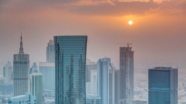 Günbatımında gökdelenler başkent Katar 'ın ticaret merkezi Doha' nın ufuk çizgisinde. Sisli havada hava manzarası. Bulutlu turuncu gökyüzü