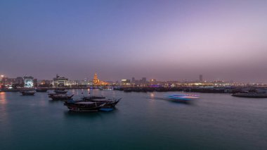 Geleneksel ahşap Dhow balıkçı tekneleriyle Doha Körfezi 'nde gece gündüz geçiş zamanı. Corniche, Doha, Katar ile müzeden görüntü