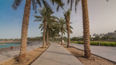 Katar 'ın başkenti Doha' da bulunan yedi kilometre uzunluğundaki Corniche 'nin bir ucunda bulunan MIA Park zaman atlamasında yürü. Avuçlar yolun her iki tarafında.