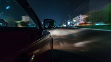 Side of Car 'dan gelen bir saçmalık. Gece otobanında hız sınırında ilerliyor. Işıklar yüksek hızda arabaya yansıyor. Modern bir şehrin hızlı ritmi. Bulanık hareket
