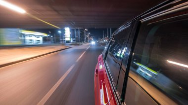 Hızlı arabanın yanından gelen bir saçmalık. Bir gece caddesinde hızla ilerliyor. Işıklar yüksek hızda arabaya yansıyor. Modern bir şehrin hızlı ritmi. Bulanık hareket