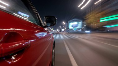 Hızlı sürüş yapan bir şehrin gece caddesinde, yüksek hızda ışık yansıtan bir yolda, hızlı sürüş yapan bir arabadan saçma sapan bir şehir görüntüsü. Modern bir şehrin hızlı ritmi. Bulanık hareket