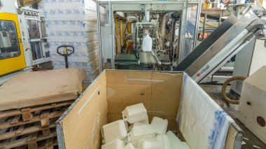 Beyaz plastik bir teneke kutu üretimi için bir fabrika. Fabrikadaki taşıyıcı. Çevre dostu üretim.