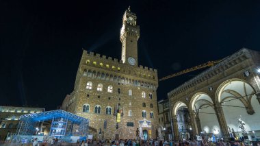 İtalya, Toskana, Floransa 'da alacakaranlıkta Piazza della Signoria' dan ünlü Arnolfo Palazzo Vecchio zaman atlaması kulesi. Tarihi binaların gece aydınlanması