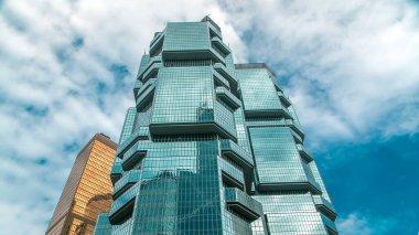 Amirallik zamanından Hong Kong Merkez İş Bölgesi 'ne bakıyorum. Arka planda bulutlu mavi gökyüzü ve cam yüzeyde yansıması olan modern kulelerin görüntüsü.