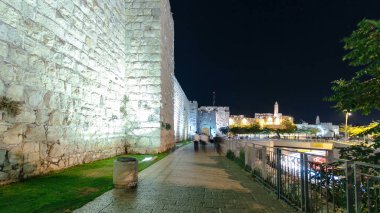 Antik Şehir 'in Gece Zamanındaki Duvarları hiperhızlandırılmış, Kudüs, İsrail. Sokakta akşam aydınlığıyla yürüyen insanlar.