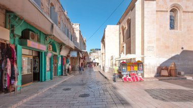 Kudüs 'ün eski kenti Kudüs' teki Kutsal Mezar 'ın yanındaki renkli çarşaf. İsrail zaman atlaması. Bu pazarda bir sürü insan geçiyor.