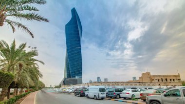 Kuveyt 'teki modern çarpık kule zaman atlaması. Kuveyt, Orta Doğu. Gün batımında palmiyeler ve trafik varken