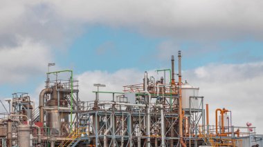 Damıtma Sütunları ve hidrojen bitkisinin çalışma ekipmanları. Arka planda bulutlar var. Bir çok boru ve tank gökyüzüne karşı endüstriyel fabrika