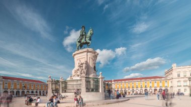 Praca do Comercio (Ticaret Meydanı). Kral 1. Jose 'nin heykeli hiperhızlandırılmış. Kral sembolik olarak yoluna çıkan yılanları eziyor. Bulutlu bir gökyüzü ve arka planda renkli evler. Lizbon, Portekiz.