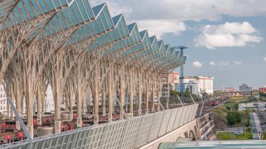 Lizbon Oriente Tren ve Otobüs İstasyonu 'nda, çelik ve cam ağaçların birbirine kenetlenerek şeffaf çatılardan oluşan sürekli bir sistem oluşturduğu zaman dilimi. Trenler gelir ve gider. Lizbon, Portekiz