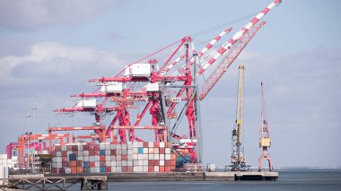 Lizbon limanındaki büyük konteyner gemilerine yük yüklemek için kullanılan konteynır terminali zaman çizelgesini ve gantry vinçlerini izleyin. Portekiz. Tejo nehrinin üzerindeki bulutlu gökyüzü