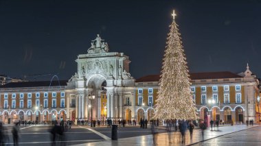 Lizbon 'daki ticaret meydanı, Noel' de yüksek bir ağaç ve geceleri kemerle aydınlandı. Dekorasyon ve tarihi mimarinin yer aldığı şenlikli atmosferin zamanlaması