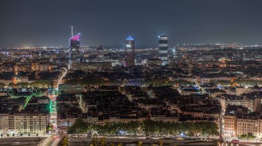 Geceleri Fourviere Hill 'den gökdelenlerle Lyon' un panoramik hava manzarası. Ufuk çizgisinde Rhone Nehri ve ikonik kent simgeleri yer alıyor. Evler çatılar ve caddelerde trafik