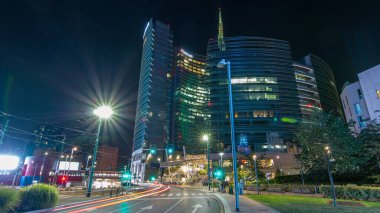 Milan Porta Nuova iş ilçe gece timelapse, Milano, İtalya içinde modern gökdelenler ile manzarası. Yolda trafik. Işık içinde pencere eşiği. Yoldan görüntülemek