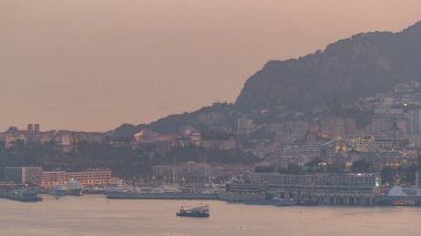 Monte Carlo 'nun şehir manzarası şatodan geceye geçiş zamanı, yaz günbatımından sonra Monako. Akşam sisi. Limandaki yatlar. Kaptan Martin 'den üst görünüm