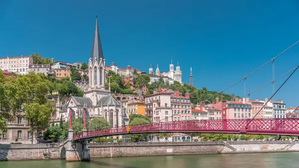 Aziz George Kilisesi, Quais de Saone ve Fourviere Bazilikası 'nın Fransa' nın Vieux Lyon kentindeki bir yaya köprüsünden hızlandırılmış zamanaşımı, tarihi mimari, yansımalar ve manzaralı nehir manzarası sergileniyor.