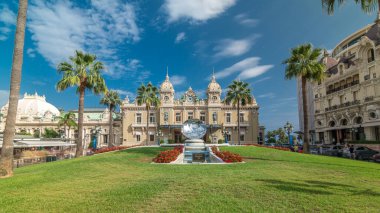 Ön görünümünde Monte Carlo timelapse hyperlapse, Monaco Grand Casino. Tarihi bina ve kare, Çeşme ve yeşil çim. Avuç içi tarafında. Mavi bulutlu gökyüzü yaz gün