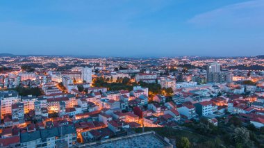 Porto 'nun eski kasabasının çatılarındaki hava manzarası sıcak bir bahar akşamında günden geceye geçişte, Porto, Portekiz' den. Işıklar yanıyor.