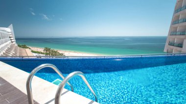 Güneşli yansımaları ve mavi su timelapse ile Otel yüzme havuzu, Sesimbra, Portekiz plajında görünümü