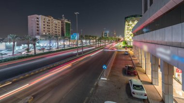 Suudi Arabistan, Riyad 'daki Kral Fahd Yolu' nun gece panoramik zaman çizelgesi. Günümüz kuleleri ve gökdelenleri ile çevrili Riyad Ulusal Kütüphanesi 'nin yakınındaki araçlarla yoğun bir trafik vardı.