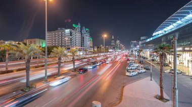 Riyad, Suudi Arabistan 'ın şehirsel gece zaman çizelgesinde aydınlık kuleler, gökdelenler, Kral Fahd Yolu ve yoğun trafik yer alıyor. Palmiyeler ve sokak lambaları alışveriş merkezinin yakınındaki ana otoyolda.