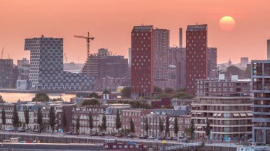 Hollanda, Rotterdam 'da gün batımında Katendrecht Yarımadası ve Maashaven Limanı' nın panoramik zaman çizelgesi. Şehir silueti, modern gökdelenler ve geleneksel Hollanda rıhtım evleri